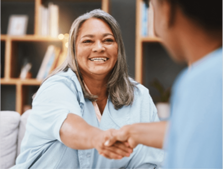 a happy woman shaking hands with a doctor (actor portrayal)