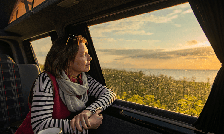 smiling woman looking out the window while traveling (actor portrayal)