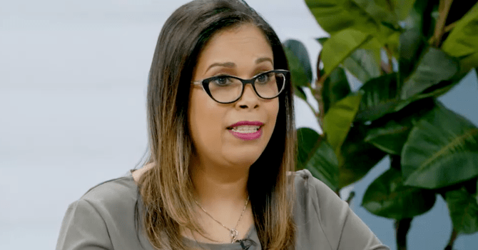 woman wearing glasses being interviewed